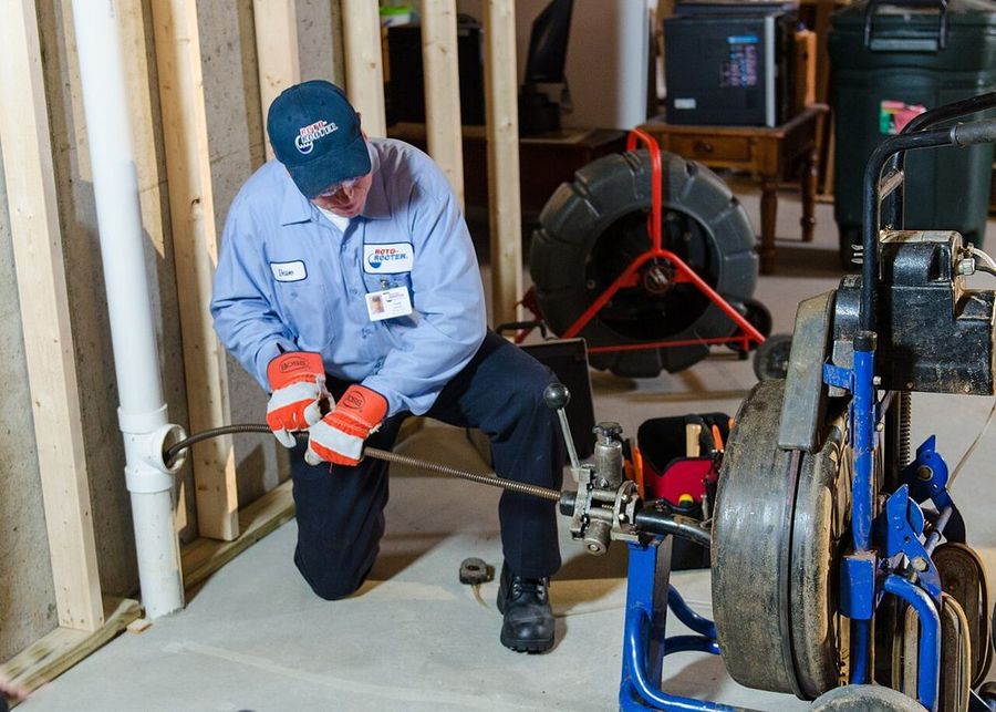 Technician running a drain cleaning machine